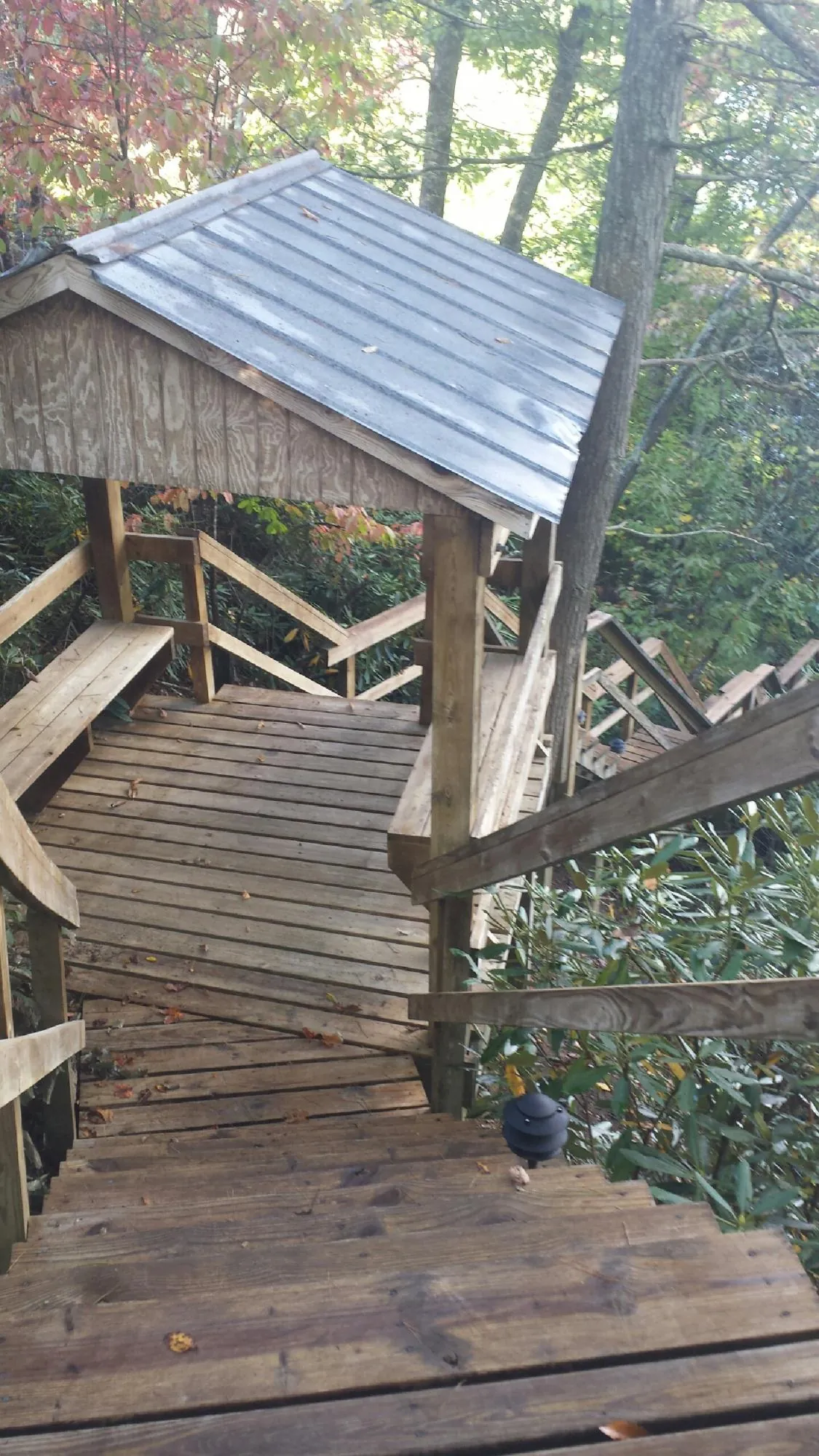 Metal roofed shelter over wooden steps on a wooded walkway — Skylight Repair & Installation work by our crew in Fishs Eddy